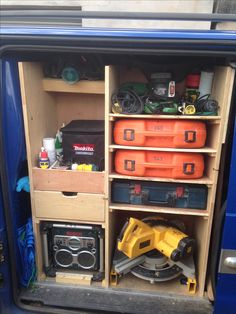 the inside of a blue van with tools and other items in its storage compartment,