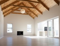 an empty room with wooden ceiling and windows