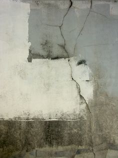 an abstract painting with white and black paint on the side of a concrete block wall