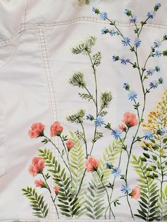 an embroidered sheet with flowers and leaves on it