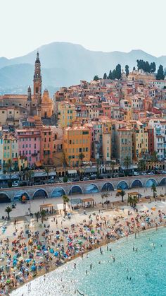 the beach in menton, france is crowded with people