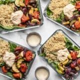 four trays filled with different types of food on top of a white tablecloth