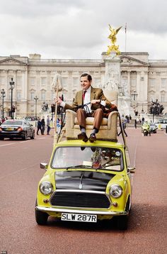 a man sitting on top of a mini car