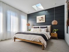 a bedroom with black and white walls, carpeted flooring and a large bed