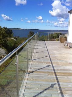 a wooden deck with metal railings overlooking the water