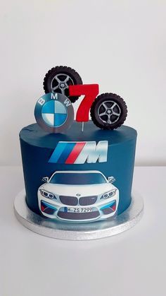 a blue cake decorated with an image of a car and the number seven on it