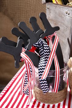 a basket filled with black and red items on top of a striped cloth covered table