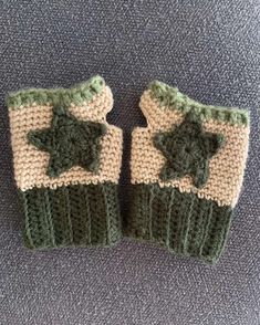 two green and white knitted mittens with stars on them