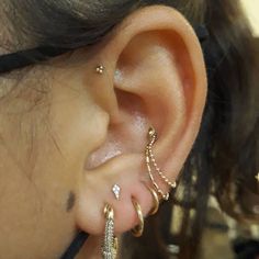 a close up of a person's ear with three different types of piercings