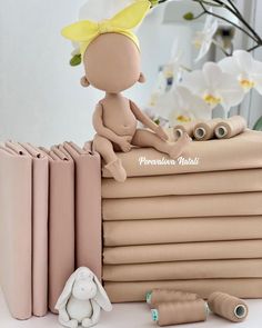 a small doll sitting on top of a stack of books