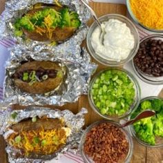 the meal is prepared and ready to be eaten on the table, including beans, broccoli, black beans, cheese, sour cream