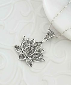 Introducing our stunning handcrafted filigree art lotus flower pendant necklace, perfect for adding a touch of elegance and sophistication to any outfit. The intricate detailing of the lotus flower, a symbol of purity and enlightenment, is showcased beautifully in this piece. Made with 925 sterling silver, the pendant's height is 1.70 inches and its width is 1.20 inches, with a 20-inch silver chain. It also comes with a silver polish cloth and luxurious gift box, making it an ideal gift for Moth Elegant Handmade Pendant Flower Necklace, Elegant Sterling Silver Jewelry For Meditation, Elegant Engraved Flower Shape Necklaces, Delicate Pendant Jewelry With Intricate Design, Bohemian Jewelry With Intricate Flower Design, Exquisite Flower Shaped Necklace For Gift, Elegant Engraved Flower Necklace, Elegant Engraved Flower Necklaces, Bohemian Flower Jewelry With Intricate Design