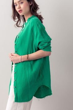 Unleash your summer wardrobe with this plush cotton shirt. Soft to the touch and lightweight, the oversized boyfriend cut and one pocket provide a stylish cover-up when the weather turns warm. The distressed hem adds an edgy finishing touch for a look that is both elegant and modern. Perfect for making a fashion statement this summer. Trendy Green Shirt With Pockets, Green Long Sleeve Beach Shirt, Oversized Green Shirt For Fall, Oversized Solid Color Shirt For Summer, Oversized Beach Shirt With Pockets, Green Shirt With Pockets For Day Out, Green Solid Color Beach Top, Oversized Green Relaxed Top, Oversized Green Cotton Blouse