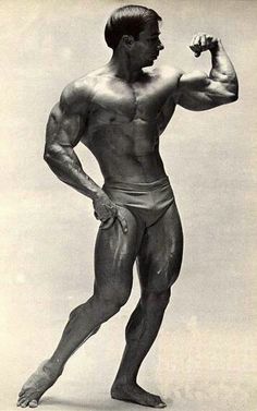 an old photo of a man flexing his muscles