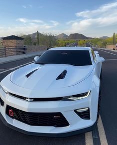 a white chevrolet camaro is parked in the parking lot