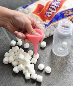 someone is pouring marshmallows into a container