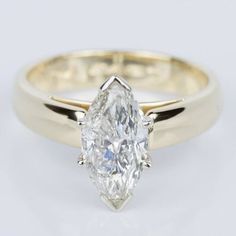 a yellow gold engagement ring with a pear shaped diamond