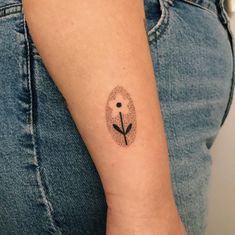 a woman's arm with a tattoo on it that has a flower in the middle