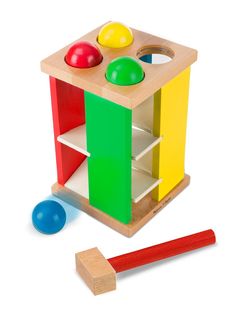 a wooden toy with two different colored balls and a piece of wood next to it