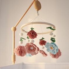 a pink and blue flower mobile hanging from a ceiling