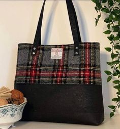 a black and red plaid purse next to a bowl of cookies