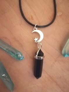 🖤 Here is a beautiful Black obsidian necklace, on a black 20 inch adjustable faux leather cord. With a silver Moon & Star charm!  🖤Enjoy the protective ground benefits of wearing this crystal pendant!   *Please choose your preferred finish from the drop down menu- *Faux leather cord - 20inch Silver plated -20 inch Stainless Steel -20 inch Spiritual Black Necklace With Moon Charm, Black Dangle Crystal Necklaces For Gift, Mystical Nickel-free Black Jewelry, Mystical Black Nickel-free Jewelry, Mystical Black Round Necklace, Black Dangle Crystal Necklace For Gift, Black Nickel-free Mystical Jewelry, Adjustable Black Moon Charm Necklace, Adjustable Silver Spiritual Crystal Necklace