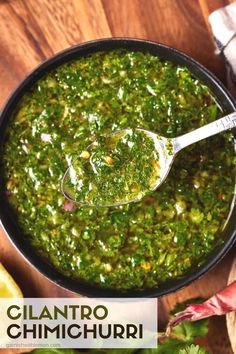 a spoon full of green salsa on top of a wooden table