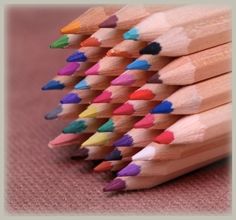 a group of colored pencils sitting next to each other