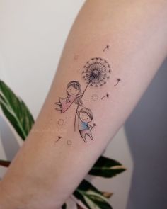 a girl holding a dandelion tattoo on her arm