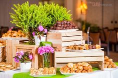 a table topped with lots of trays filled with different types of food and flowers