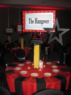 a red table topped with plates and silverware under a sign that says the hangover