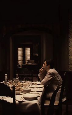 a man sitting at a dinner table in the dark