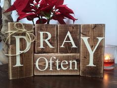 a wooden block with the words pray often on it next to a potted plant