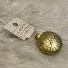 a gold flask shaped like a christmas tree ornament next to a tag