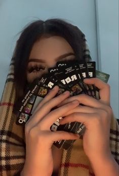 a woman covering her face with some cards