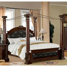 a bedroom with four poster bed, dresser and mirror