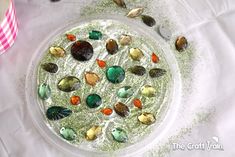 a bowl filled with lots of different types of rocks and gravel on top of a table