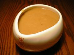 a white bowl filled with soup on top of a wooden table