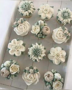 cupcakes decorated with white flowers and green leaves