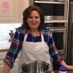 a woman standing in front of a mixing bowl on a kitchen counter next to an oven