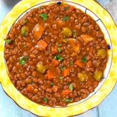 a yellow bowl filled with beans and vegetables