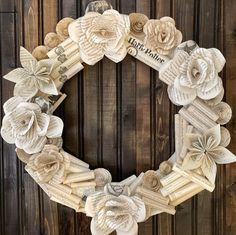 a wreath made out of old book pages with paper flowers on the front and sides