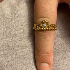 a woman's hand with a gold ring on it and a diamond in the middle