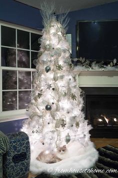 a white christmas tree with lights and ornaments