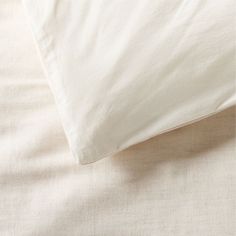 an unmade bed with white sheets and pillows