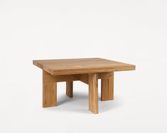 a square wooden table with two legs and one leg raised up to the side, against a white background