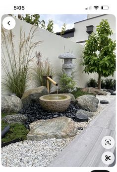 an image of a garden with rocks and plants in the center, water feature on top