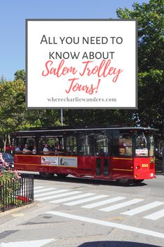 a red trolley driving down a street next to a sign