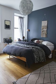 a bedroom with blue walls and wooden floors