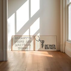 two signs sitting on top of a hard wood floor next to a window with sunlight coming in